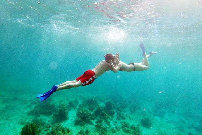 Catamaran Cruise Full Day Tour to Reef, Caves and Negril Beach - Boarding the catamaran from the water