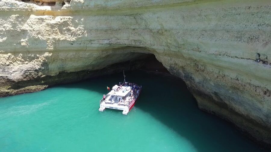 Quarteira: Benagil Cave Guided Catamaran Day Cruise & Drink - From Vilamoura Marina toward the Algarve cliffs
