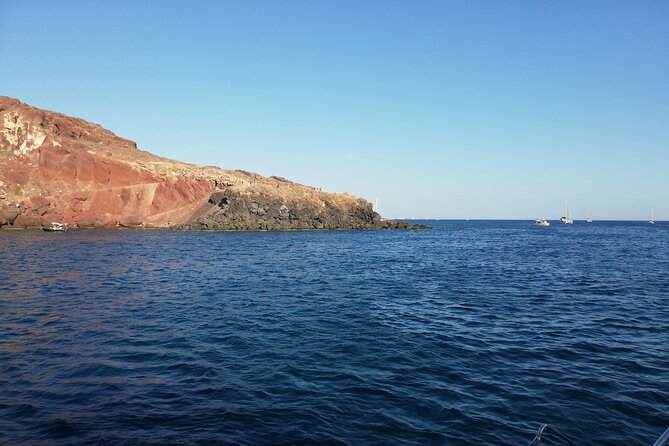Santorini Catamaran Cruise with Fresh Meal and Open Bar - Red Beach, where the cliffs turn rust red