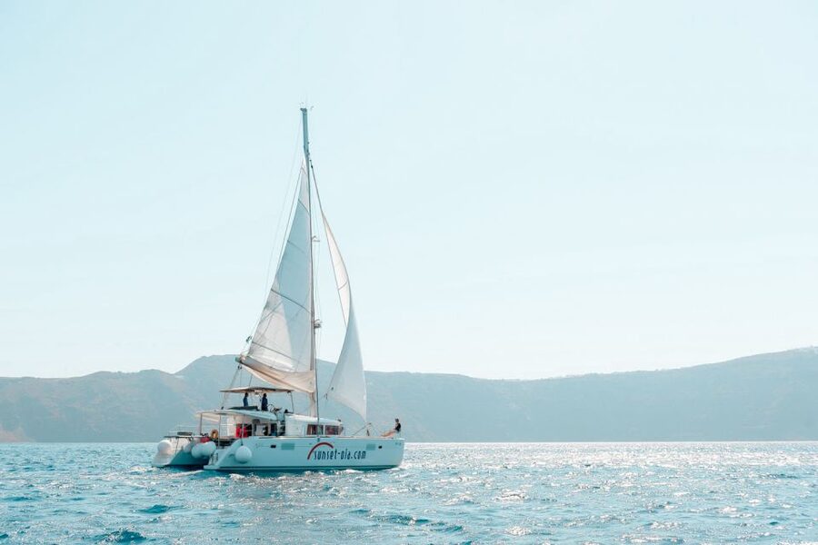 Santorini: Catamaran Tour with BBQ Meal and Unlimited Drinks - White Beach and the onboard BBQ
