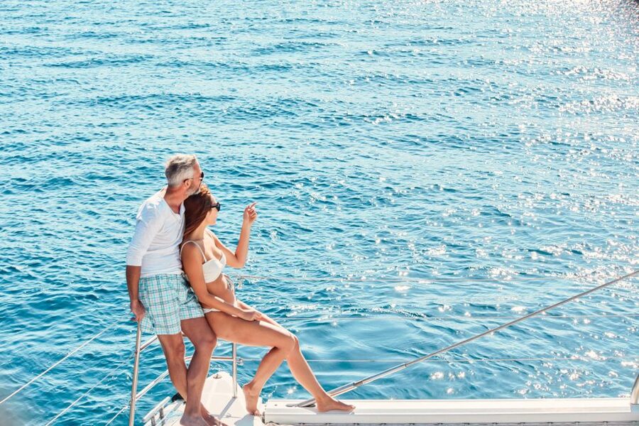 Santorini: Catamaran Tour with BBQ Meal and Unlimited Drinks - Pickup, ports, and the first hour aboard