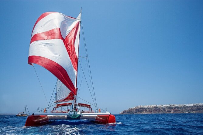 Santorini Cruise on Catamaran with BBQ & Open Bar - Passing the Old Lighthouse, Indian Rock, and Black Mountain