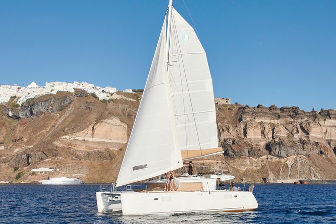 Santorini Gold Catamaran Cruise with BBQ, Drinks and Hotel Pickup - White Beach and the Akrotiri lighthouse