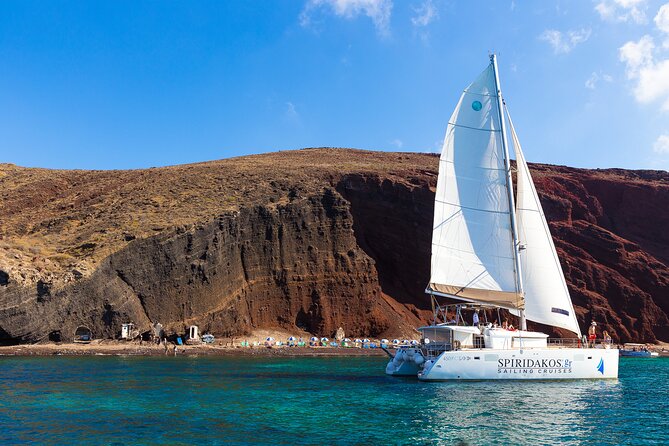 Santorini Private Catamaran Cruise with BBQ, Open Bar & Transfers - Red Beach gives you Santorini’s volcanic opening scene